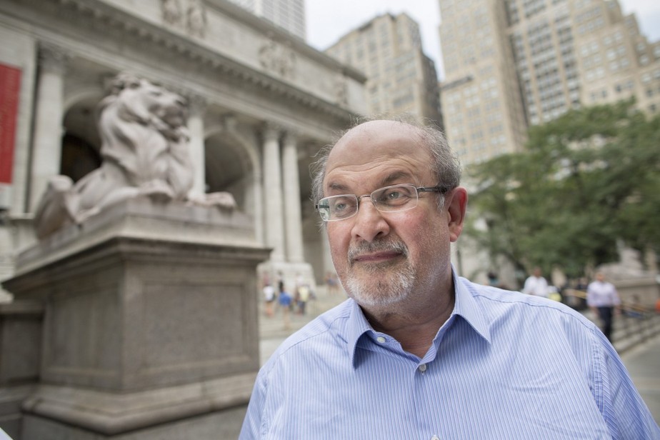 Escrito Salman Rushdie, fotografado em frente à biblioteca pública de Nova York