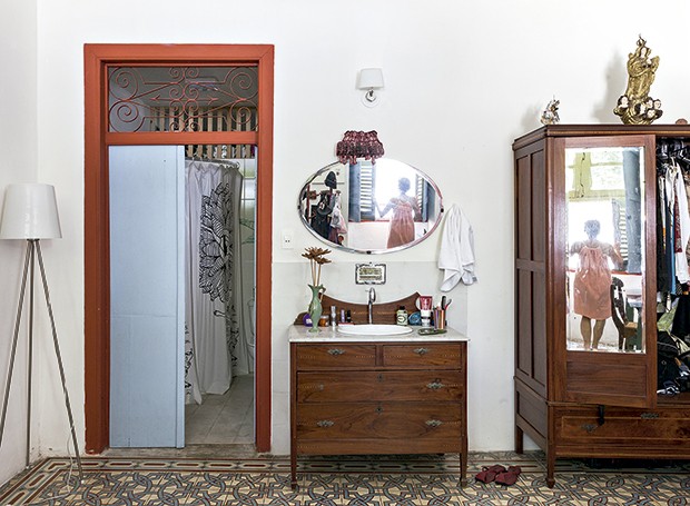 Suíte de Cibele: luminária contemporânea e um antigo armário compõem o ambiente, que tem ainda a pia instalada em um móvel, ao lado da porta do banheiro (Foto: Lufe Gomes/ Life by Lufe)