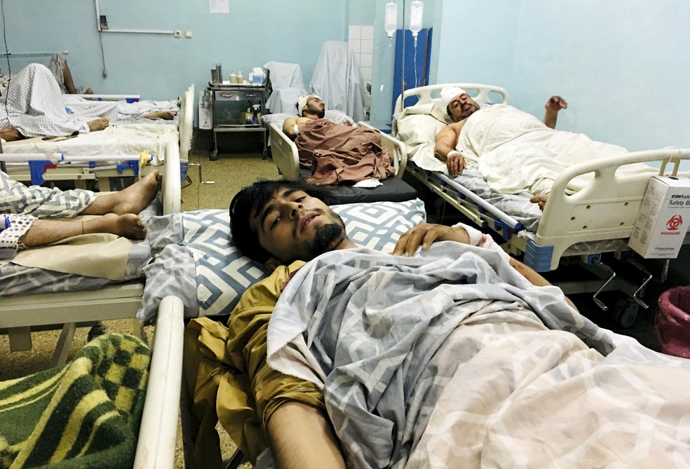 Afegãos feridos internados em hospital de Cabul após o atentado terrorista no aeroporto de Cabul, no Afeganistão, em 26 de agosto. Dois homens-bomba e homens armados atacaram afegãos que se aglomeravam no portão Abadia e soldados americanos que faziam a triagem para os voos de retirada do país. — Foto: Mohammad Asif Khan/AP