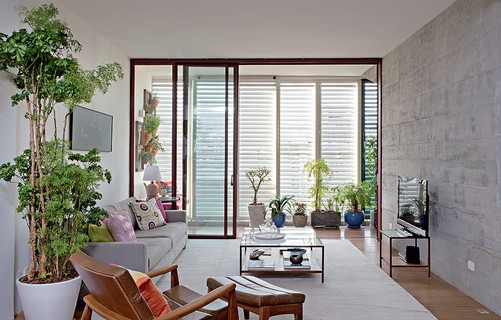 Com muitas plantas, a sala do seu apartamento vai parecer um verdadeiro quintal. O verde pode estar em vasos apoiados no chão ou pendurados na parede, como no projeto do escritório Apiacás Arquitetos