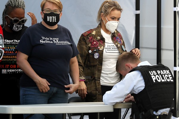 A atriz Alyssa Milano e seus colegas de protesto sendo detidos por um policial após manifestação em frente à Casa Branca (Foto: Getty Images)
