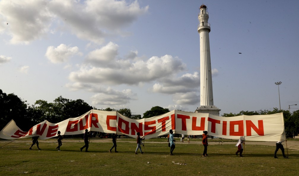 Apoiadores de sindicatos de esquerda carregam um cartaz que diz "salve a nossa Constituição" na frente do Shaheed Minar, em Calcutá, na Índia. — Foto: Bikas Das/AP