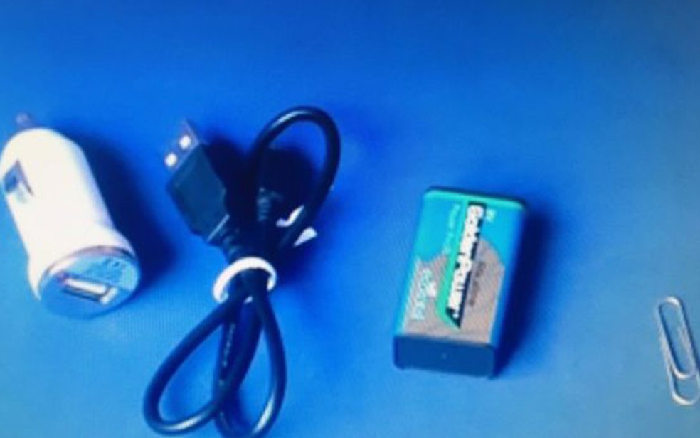 Itens essenciais para carregar um celular sem eletricidade: adaptador USB para carros, cabo do próprio telefone, pilha de 9 volts e clipe de metal (Foto: YouTube/Mundo Top)