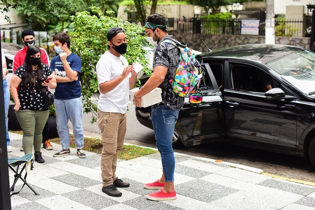 Arcrebiano conversa e posa com fãs ao chegar a flat (Foto: Leo Franco/AgNews)