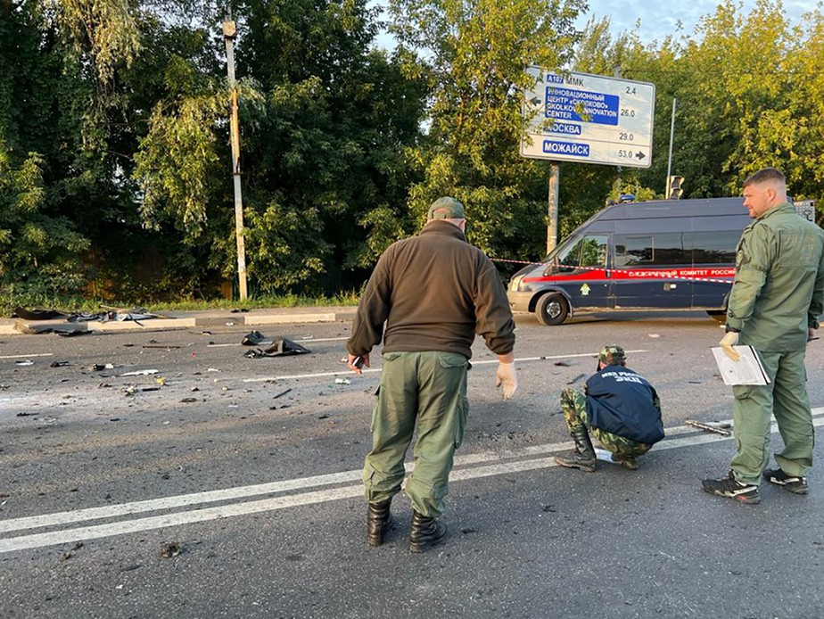 Agentes inspecionam o local onde ocorreu o atentado contra Daria Dugina, nos arredores de Moscou
