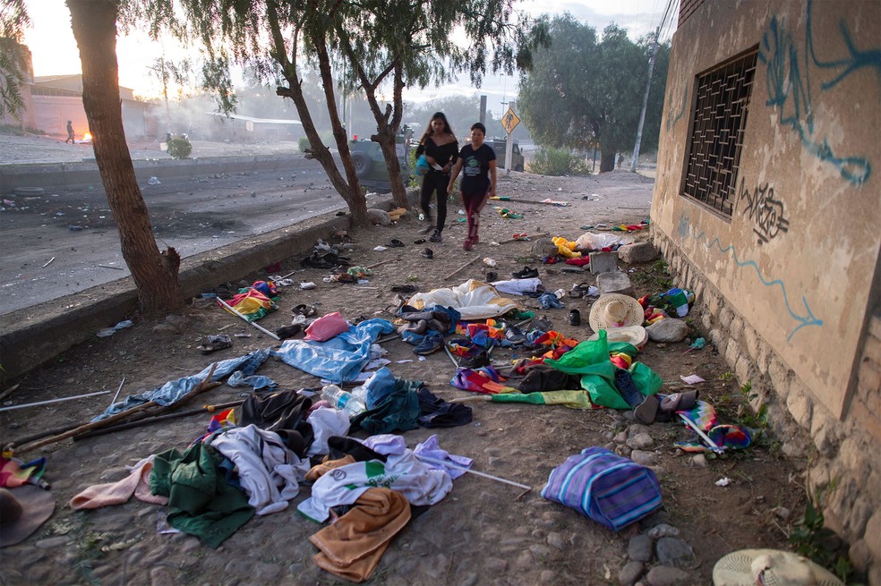 Mulheres passam por pertences abandonados por apoiadores de Evo Morales em Sacaba, perto de Cochabamba, após confronto de sexta-feira (15) — Foto: Danilo Balderrama/Reuters