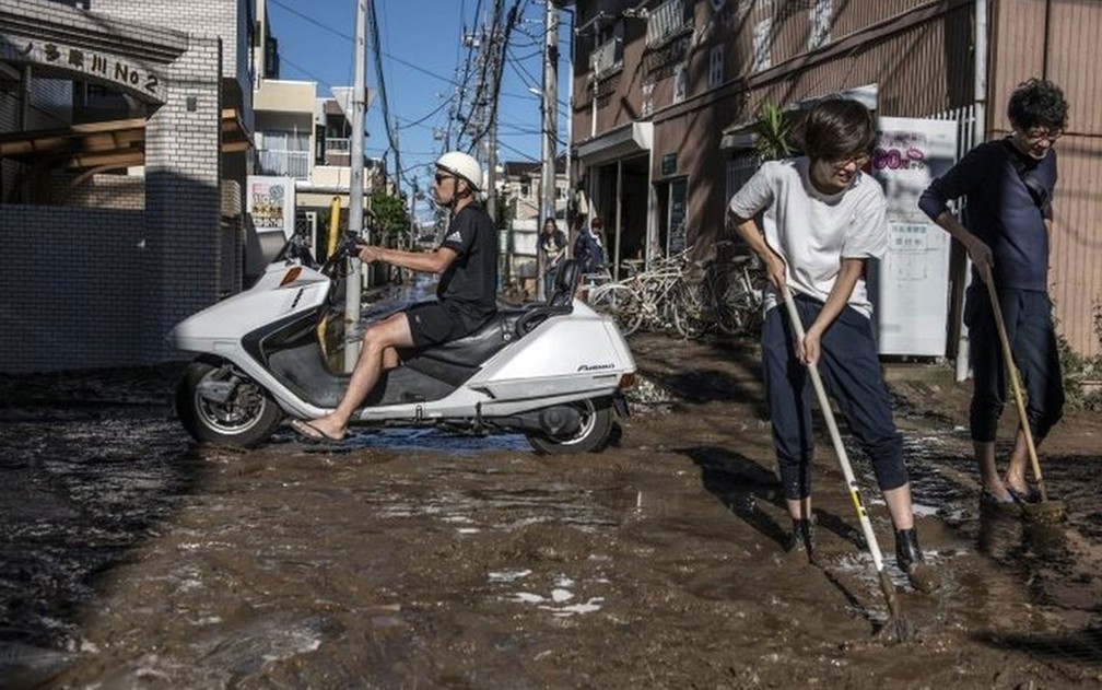 Moradores limpam a destruição em Kawasaki, no Japão, depois do tufão — Foto: Getty Images/BBC