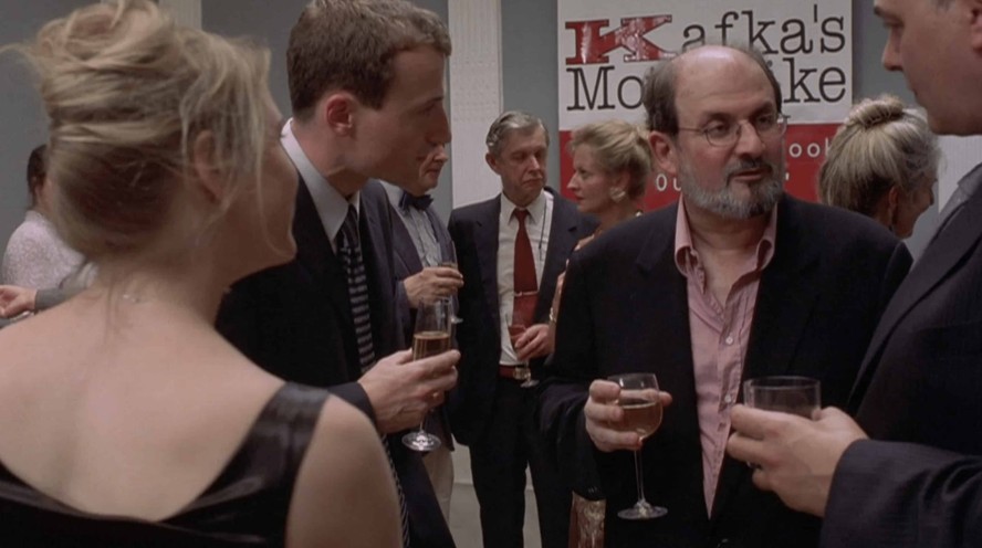 O escritor Salman Rushdie em cena do filme 'O diário de Bridget Jones'; de costas, a protagonista vivida por Renée Zellwegger