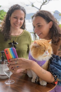 A tutora Bárbara, junto do gato influenciador Ravioli, do perfil @ravioliogato, conversando com Sabina Scardua (Foto: Tiago Morena/ Sambacine)