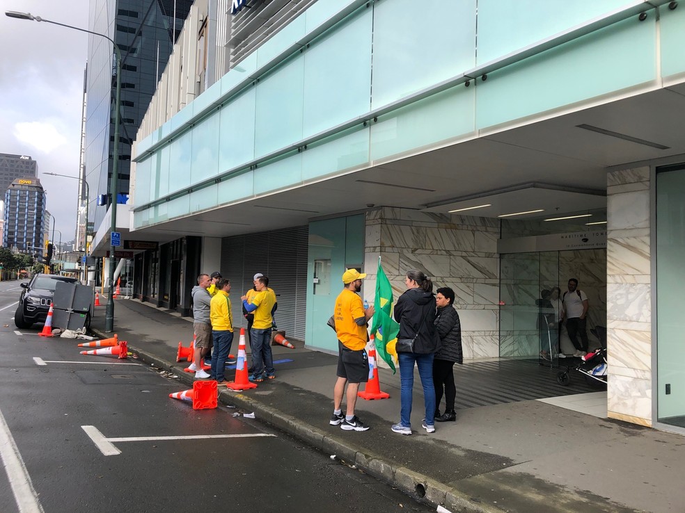 Fila em frente à Embaixada brasileira em Wellington tem eleitores vestidos de vermelho e de verde e amarelo — Foto: Luísa Pécora/g1