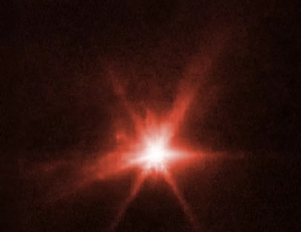 O telescópio capturou a imagem do choque do asteroide Dimorphos com a sonda enviada pela Nasa para tentar desviar a trajetória do astro celeste — Foto: NASA/ESA/CSA/STSCI/C.THOMAS/I.WONG (BBC News)