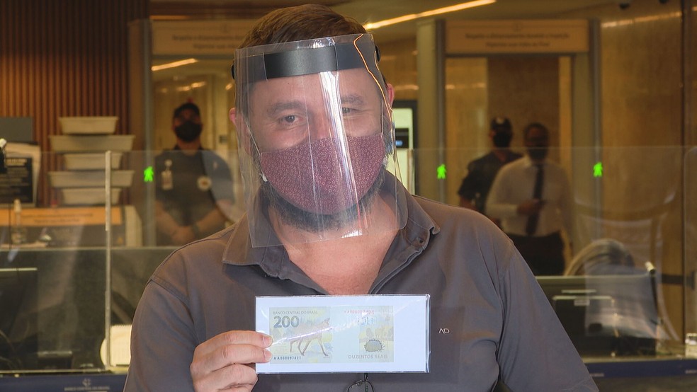 Bombeiro militar da reserva Athos Camargo é colecionador e foi primeiro garantir nova cédula de R$ 200, na sede do Banco Central, em Brasília — Foto: TV Globo/Reprodução