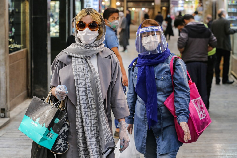 25 de abril: mulheres com máscaras e equipamento de proteção contra a Covid-19 fazem compras em Teerã, no Irã. — Foto: Atta Kenare/AFP