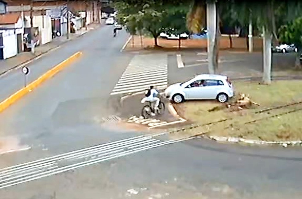 Ciclista precisou frear para não ser atingido pelo carro desgovernado que invadiu canteiro e atravessou linha de trem — Foto: Reprodução/Videomonitoramento/Prefeitura de Ourinhos