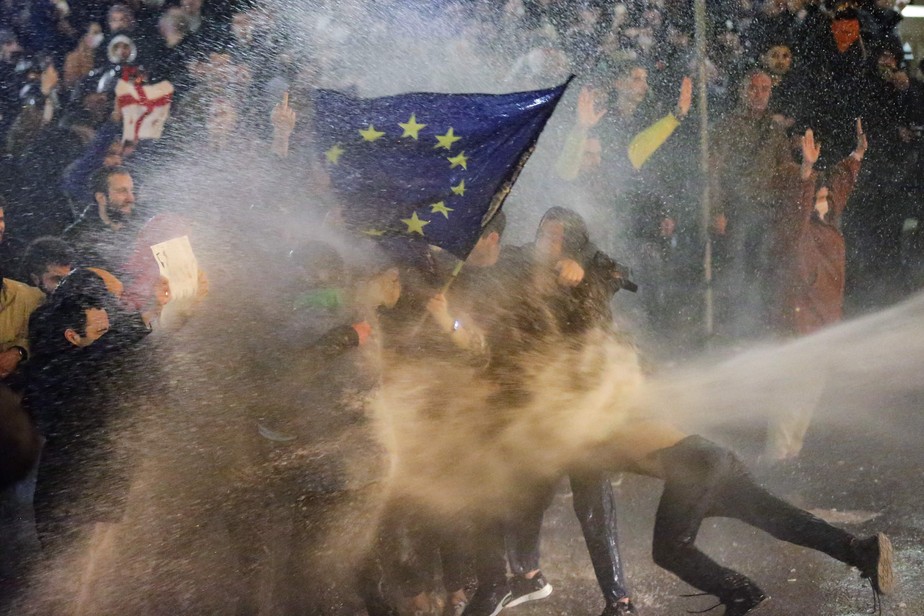 Manifestantes são alvejados por jatos d'água da polícia de choque da Geórgia, em Tbilisi, em protesto contra regularização da imprensa