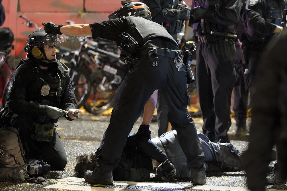 Policiais socorrem homem ferido durante protesto em Seattle — Foto: Ted S. Warren/AP
