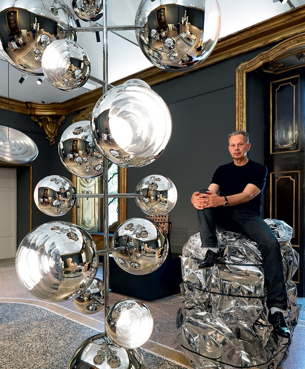 O designer Tom Dixon em frente ao pendente Mirror Ball, o primeiro protótipo de policarbonato 100% reciclado, em sua exposição comemorativa ‘Twenty’, no Palazzo Serbelloni (Foto: Allegra Martin/ Divulgação)