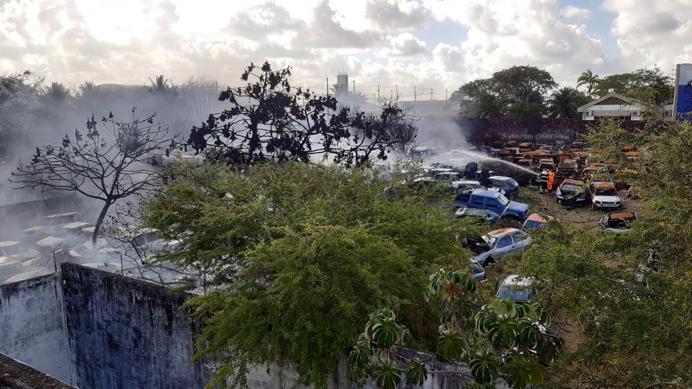 Bombeiros trabalham para tentar conter as chamas no pátio de veículos apreendidos da delegacia de plantão da Zona Norte de Natal. — Foto: Sérgio Henrique Santos/Inter TV Cabugi
