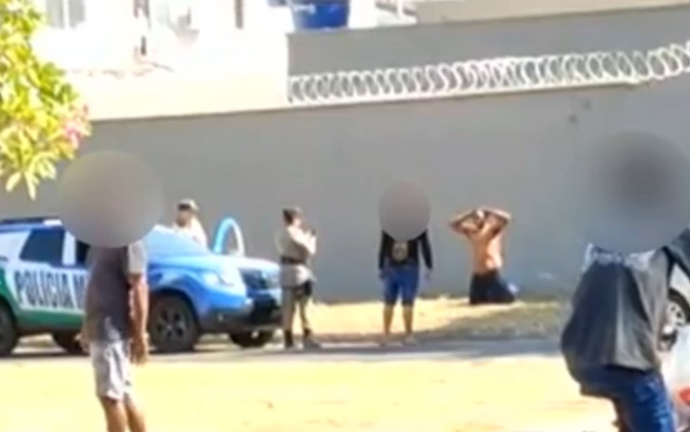 Ex-lutador de MMa José Carlos se ajoelha com as mãos na cabeça antes de ser baleado por PMs em Goiânia, Goiás — Foto: Reprodução/TV Anhanguera