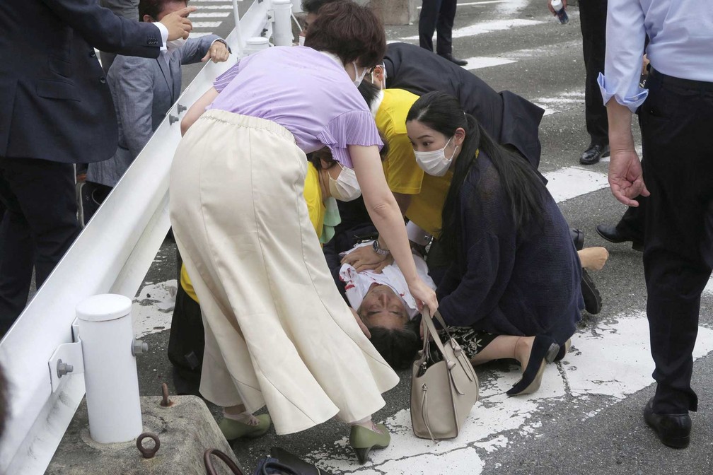 O ex-primeiro-ministro japonês Shinzo Abe no chão, com as mãos no peito, após ser baleado no Japão — Foto: Kyodo / via REUTERS