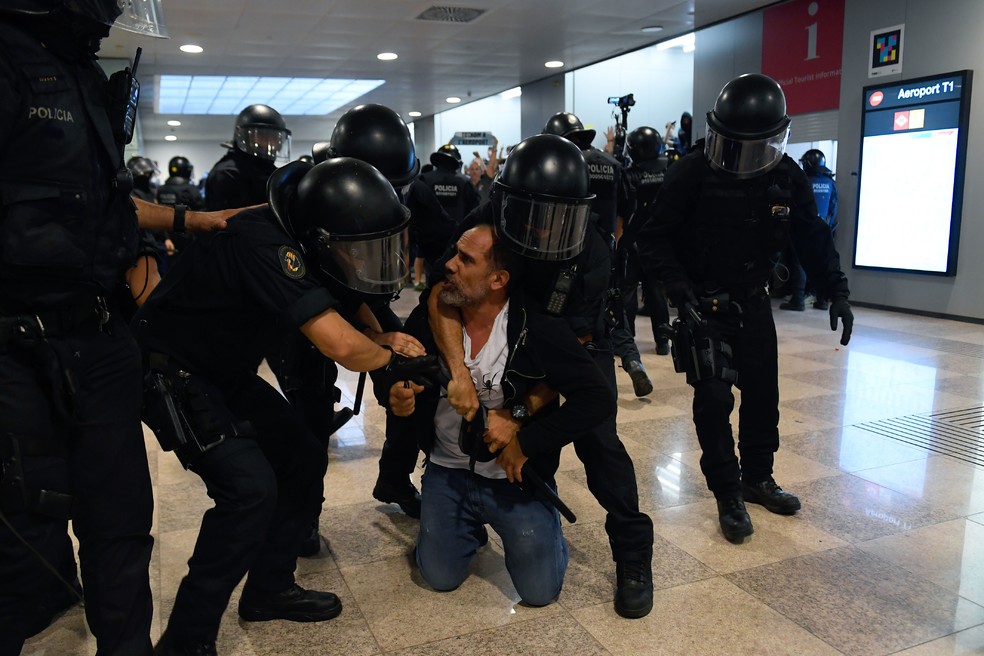 Manifestante é preso durante protesto no aeroporto El Prat, em Barcelona, nesta segunda-feira (14)  — Foto: Josep Lago / AFP