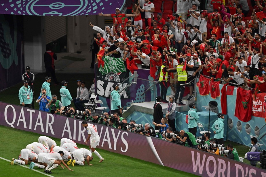 Jogadores do Marrocos se ajoelham diante da torcida marroquina para comemorar a vaga nas oitavas de final da Copa do Mundo