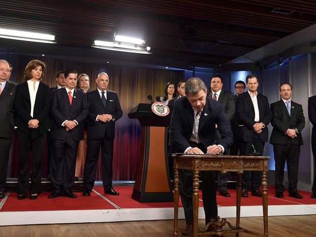 O presidente da Colômbia, Juan Manuel Santos, assina decreto em que convoca oficialmente o plebiscito sobre acordo de paz com as Farc (Foto: Colombian Presidency/Handout via REUTERS)