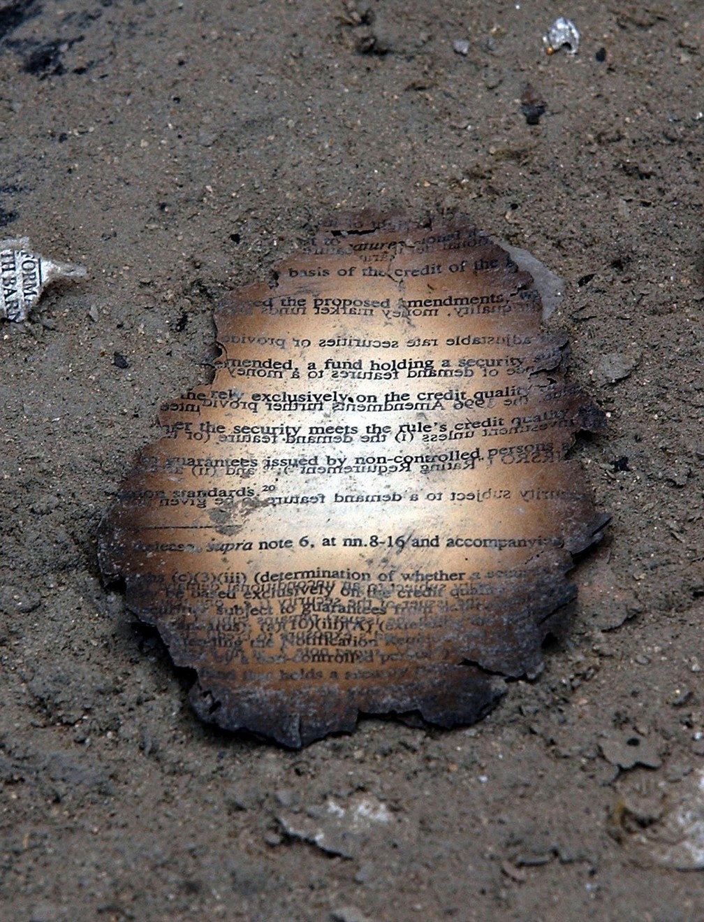 Resto da folha de um documento queimado é visto em meio ao pó que se acumulou nas ruas em área próxima ao World Trade Center, em Nova York, após o atentado terrorista do 11 de Setembro — Foto: Stan Honda/AFP/Arquivo