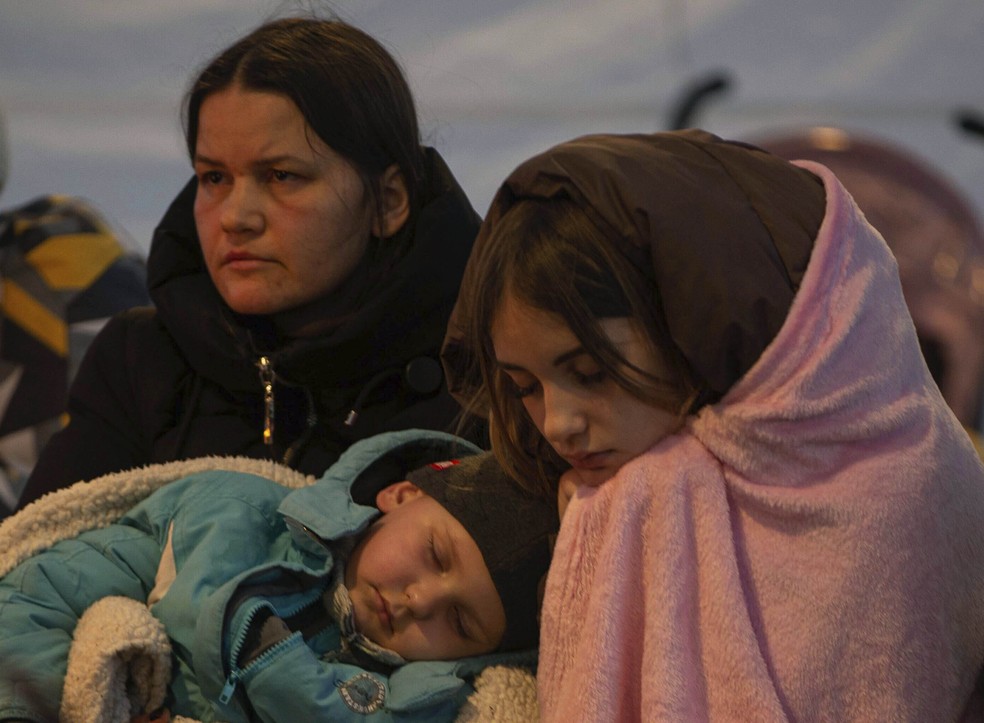 Refugiados, a maioria mulheres com crian&ccedil;as, descansam depois de chegar na fronteira com a Pol&ocirc;nia &mdash; Foto: AP Photo/Visar Kryeziu