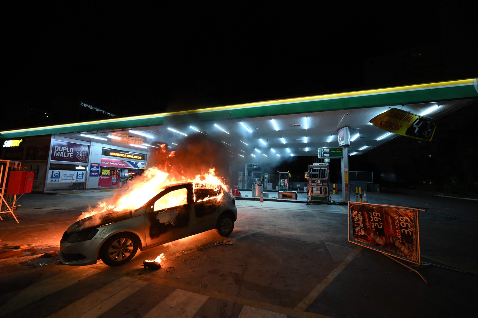 Carro incendiado em um posto de gasolina, após confrontos entre a polícia e apoiadores do presidente Jair Bolsonaro — Foto: EVARISTO SA / AFP