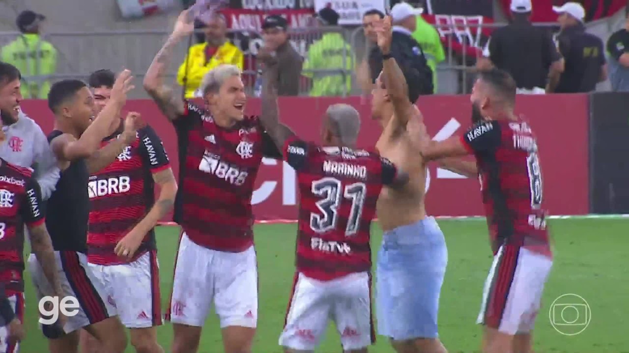 Jogadores do Flamengo comemoram a classifica&ccedil;&atilde;o com torcedor que invadiu o campo