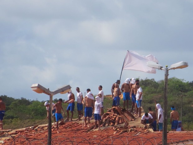 Presos voltaram a ocupar os telhados dos pavilhões com paus, pedras e bandeiras com siglas de facções criminosas (Foto: Andrea Tavares/ G1) Presos voltaram a ocupar os telhados dos pavilhões com paus, pedras e bandeiras com siglas de facções criminosas (Foto: Andrea Tavares/ G1)
