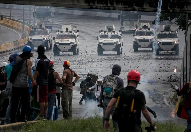 Manifestantes enfrentam as forças da Guarda Nacional em Caracas, em confronto que deixou um estudante morto (Foto: Miguel Gutiérrez/EFE)