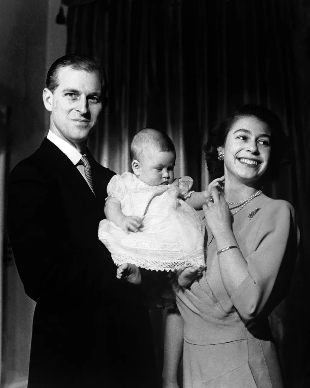 Segurando um príncipe Charles de seis meses de idade, enquanto a rainha observa (1949) (Foto: Getty Images)