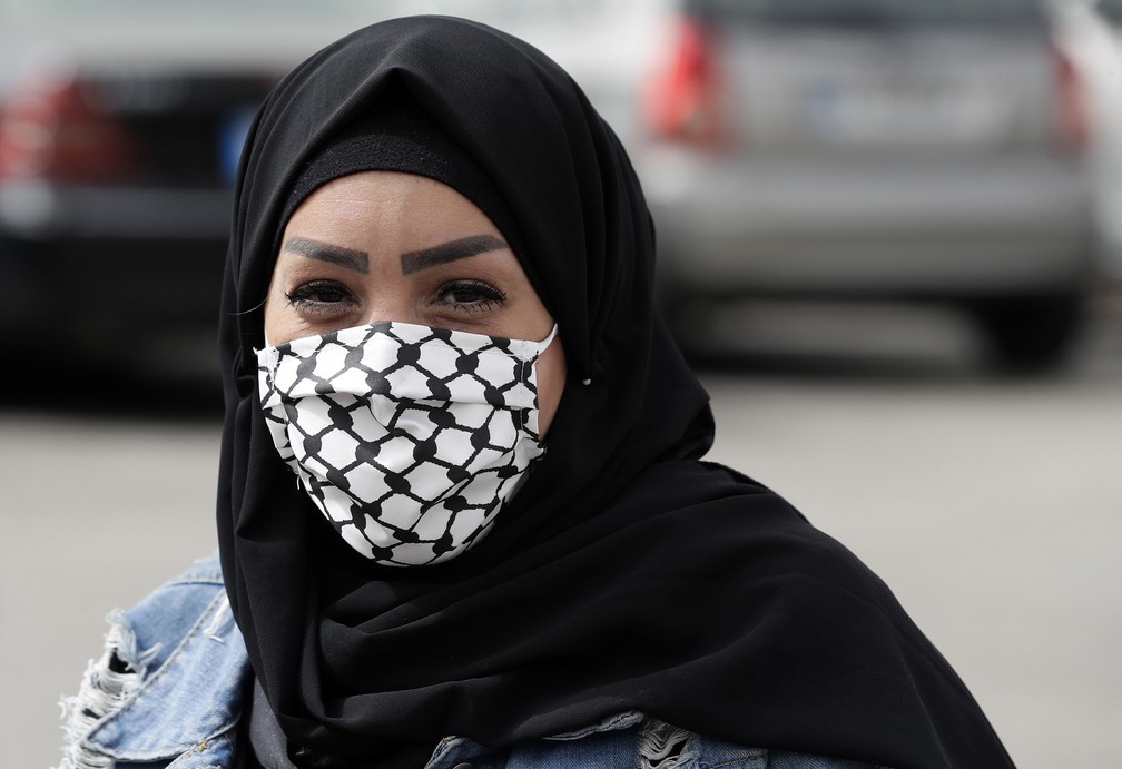 Uma mulher usa máscara de proteção com os padrões do keffiyeh, o cachecol xadrez usado pelos palestinos para simbolizar a luta, no Líbano — Foto: Joseph Eid/AFP