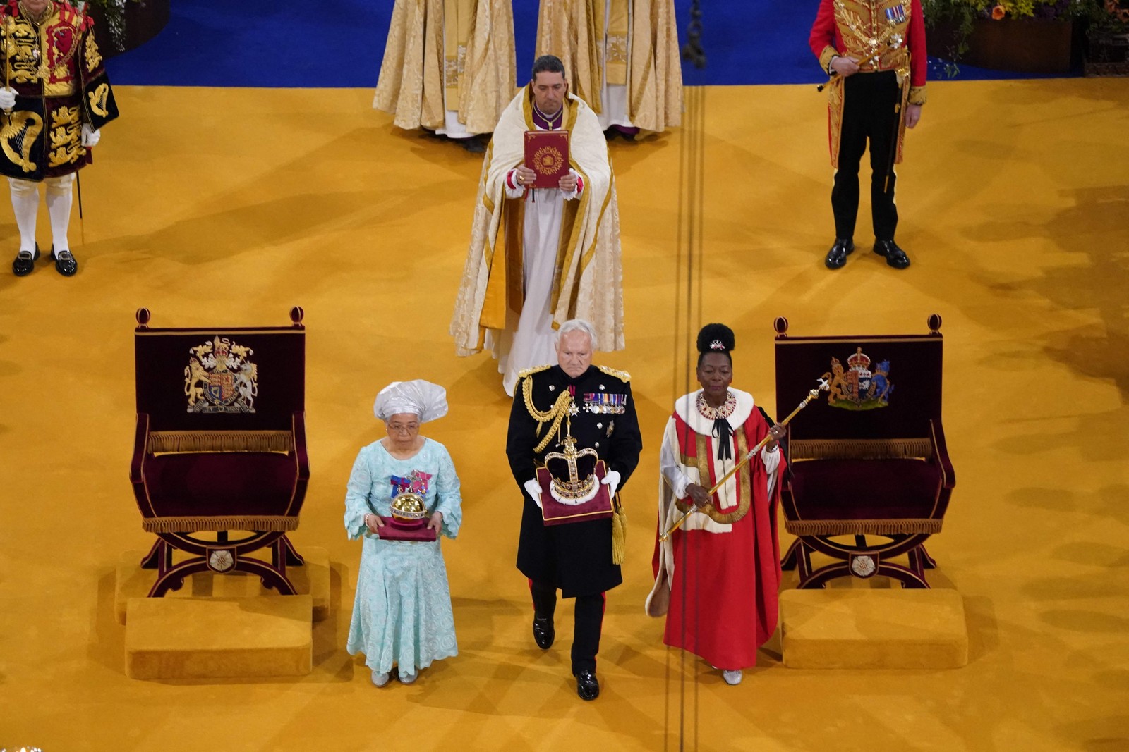 O Orbe, o Cetro com Pomba e a Coroa do Estado Imperial são levados ao trono antes das coroações  — Foto: Andrew Matthews / POOL / AFP