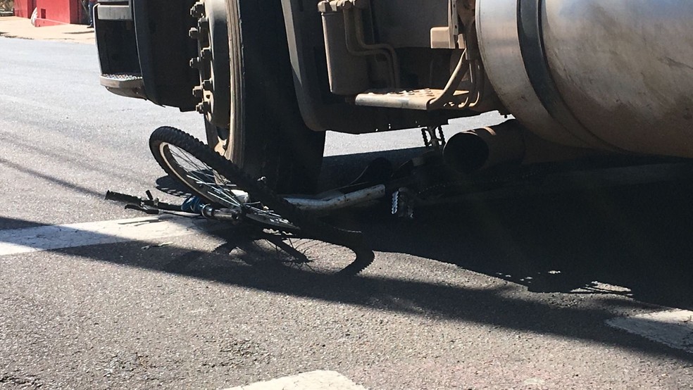 Após ser atingido, ciclista foi parar embaixo da carreta bitrem — Foto: Carlos Volpi/TV Fronteira 