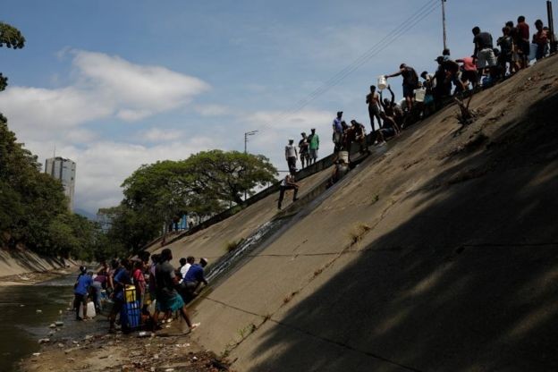 Alguns moradores chegaram a coletar água do Rio Guaire, conhecido pela poluição  (Foto: Reuters/via BBC News Brasil)
