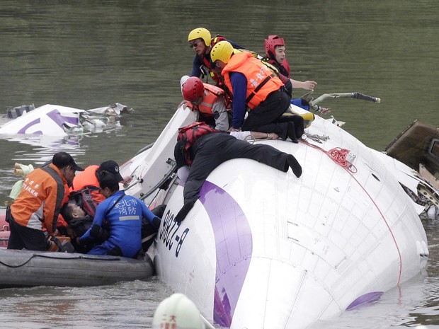Resgate puxa passageiro de dentro do avião que caiu no rio em Taipei, em Taiwan (Foto: Pichi Chuang/Reuters)