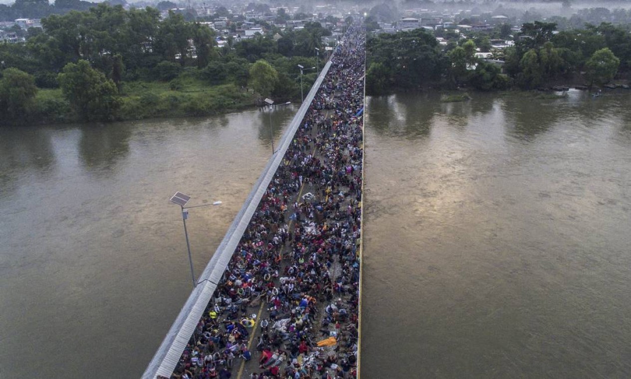 Caravana de migrantes hondurenha ruma em direção aos EUA, na ponte da fronteira internacional Guatemala-México, em Hidalgo, no México — Foto: PEDRO PARDO / Agência O Globo - 20/10/2018 