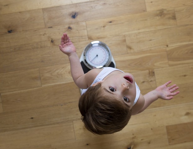 Criança se pesa na balança (Foto: Getty Image)