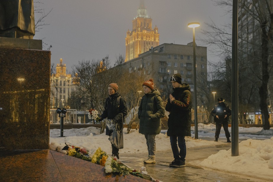 Pessoas deixam flores na estátua da poetisa e escritora ucraniana Lesya Ukrainka em Moscou, em memória aos mortos por um ataque de míssil russo em Dnipro, na Ucrânia. este mês