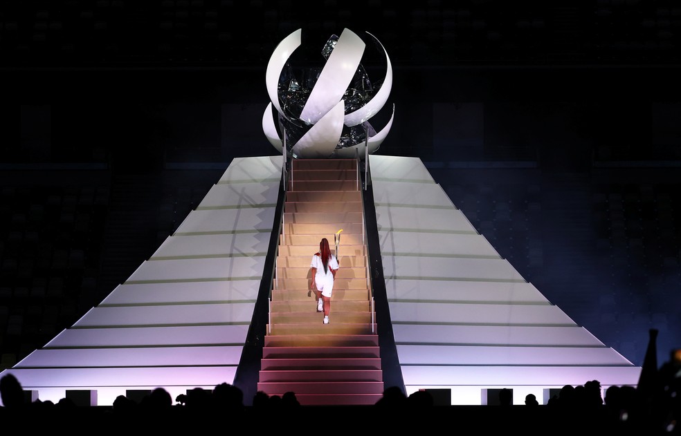 Naomi Osaka caminha para acender a tocha olímpica durante a cerimônia de abertura dos Jogos Olímpicos de Tóquio, no Japão — Foto: Stefan Wermuth/Reuters