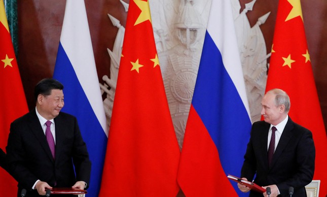 O presidente russo Vladimir Putin e seu colega chinês Xi Jinping durante uma cerimônia em Moscou