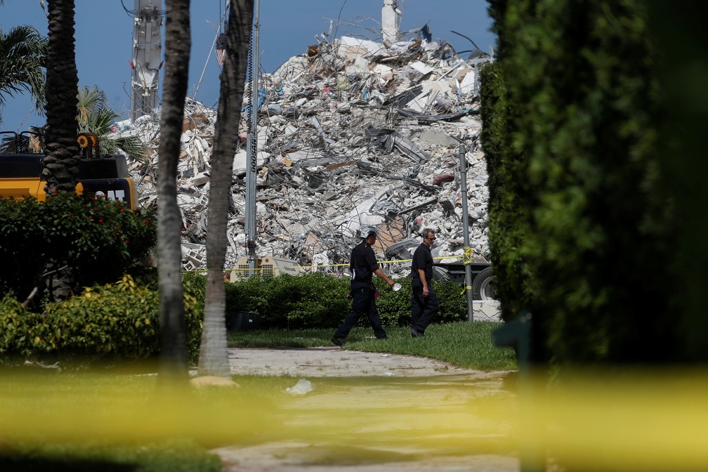 Socorristas caminham diante do entulho do Champlain Towers South, em Surfside, regi�o de Miami (EUA), nesta quinta (8) � Foto: Shannon Stapleton/Reuters