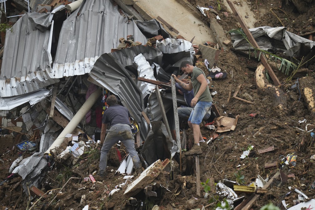 Moradores procuram por vítimas em uma área atingida pelas chuvas e deslizamentos em Petrópolis (RJ) — Foto: Silvia Izquierdo/AP
