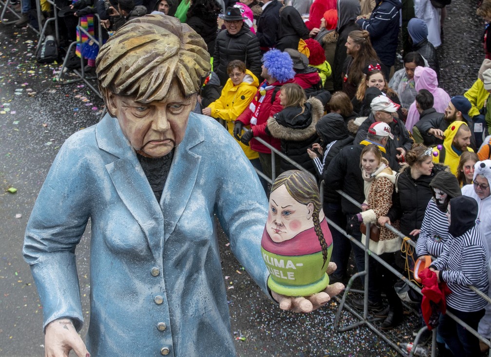 Carnaval em Mainz, na Alemanha, teve uma figura representando a chanceler alemã Angela Merkel com uma boneca russa nas mãos com a imagem da ativista ambiental Greta Thunberg — Foto: Michael Probst/AP Photo.