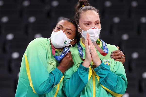 TOKYO, JAPAN - AUGUST 08: Player Fernanda Rodrigues #16 of Team Brazil reacts with team mate as they receive their Silver Medals during the Victory Ceremony following the Women's Gold Medal Volleyball match between Brazil and United States on day sixteen  (Foto: Getty Images)