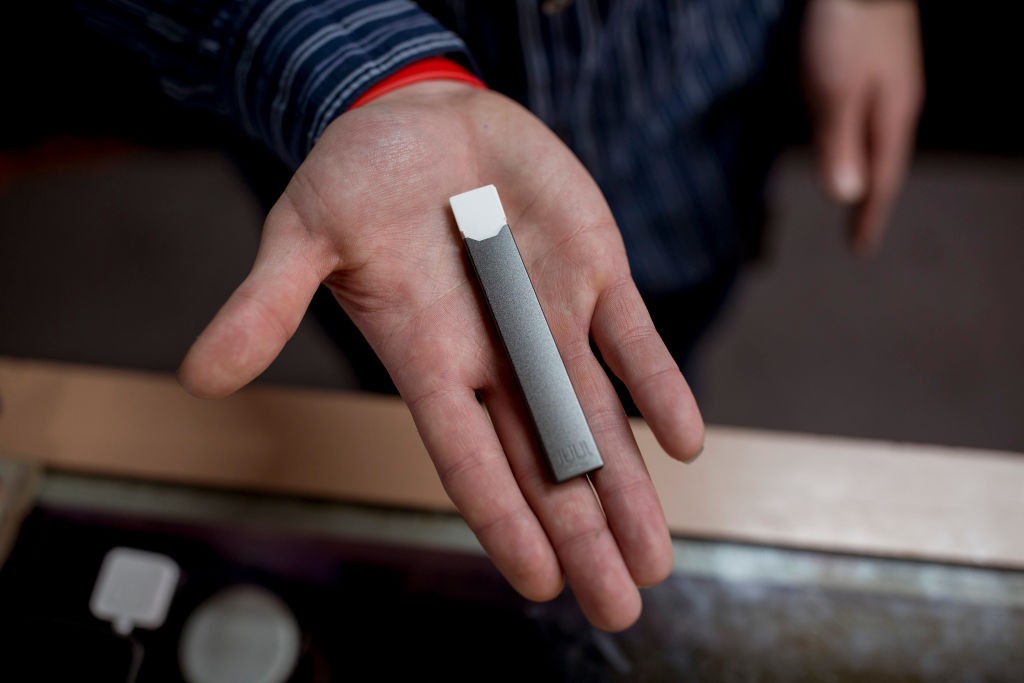 PORTLAND, ME - DECEMBER 7: Ryan Purington, an employee at Lucky Juju, holds a JUUL vape in his hand. The store started stocking the vapes last month and Purington said that they are "flying off" the shelves because they are discreet, easy to use and power (Foto: Portland Press Herald via Getty )