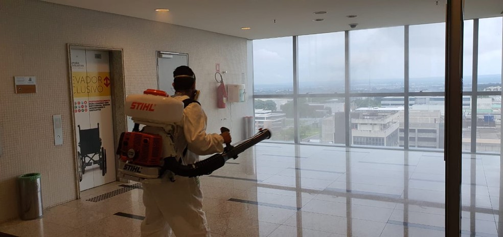 Homem sanitiza vidros na Câmara Legislativa do DF após deputado distrital Hermeto ser diagnosticado com Covid-19 — Foto: CLDF/ Divulgação